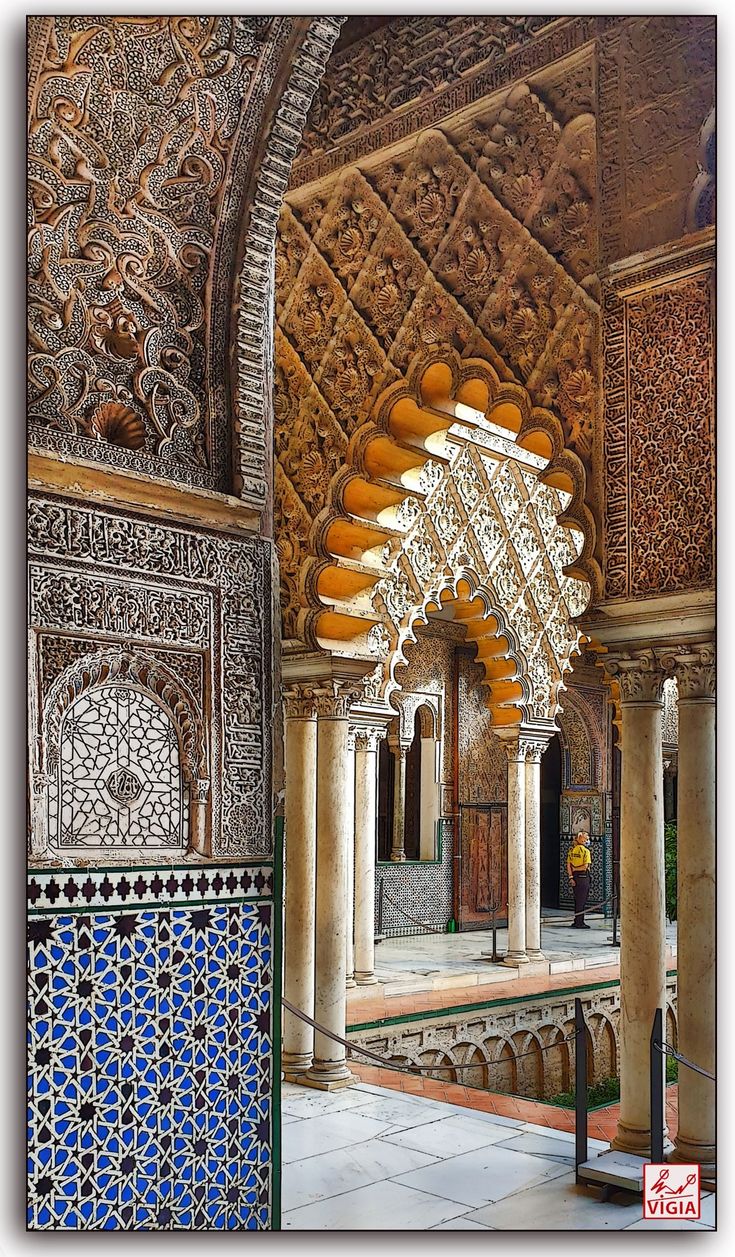 the interior of an ornate building with blue and white tiles on the walls, arches and columns