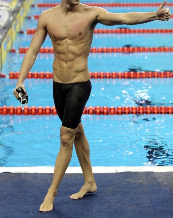 a man standing on top of a swimming pool holding his arm out to the side