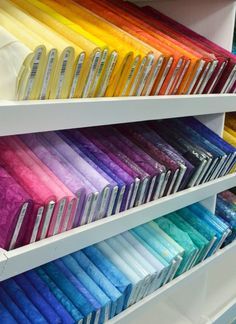 the shelves are filled with different colored papers