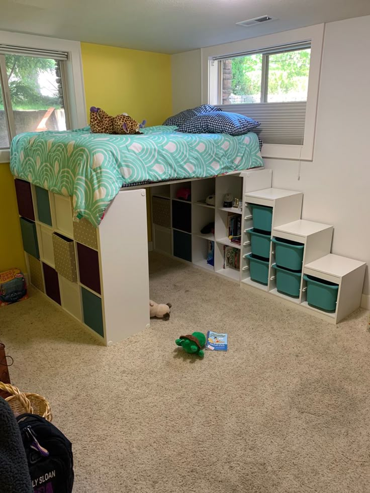 a bedroom with a loft bed and storage boxes on the floor in front of it