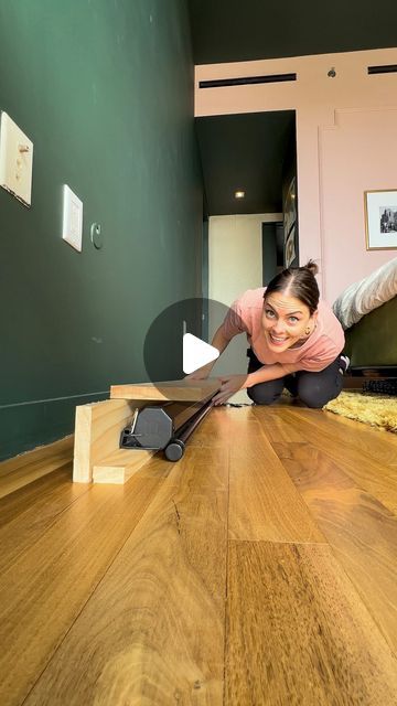 a woman laying on the floor with a skateboard in her hand and smiling at the camera