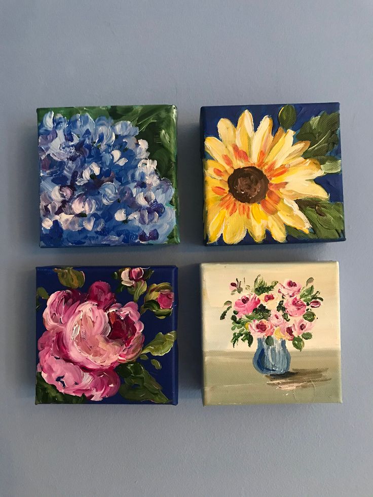 four square paintings with flowers painted on them