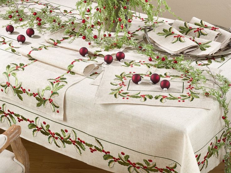 the table is covered with red berries and greenery, along with white linens