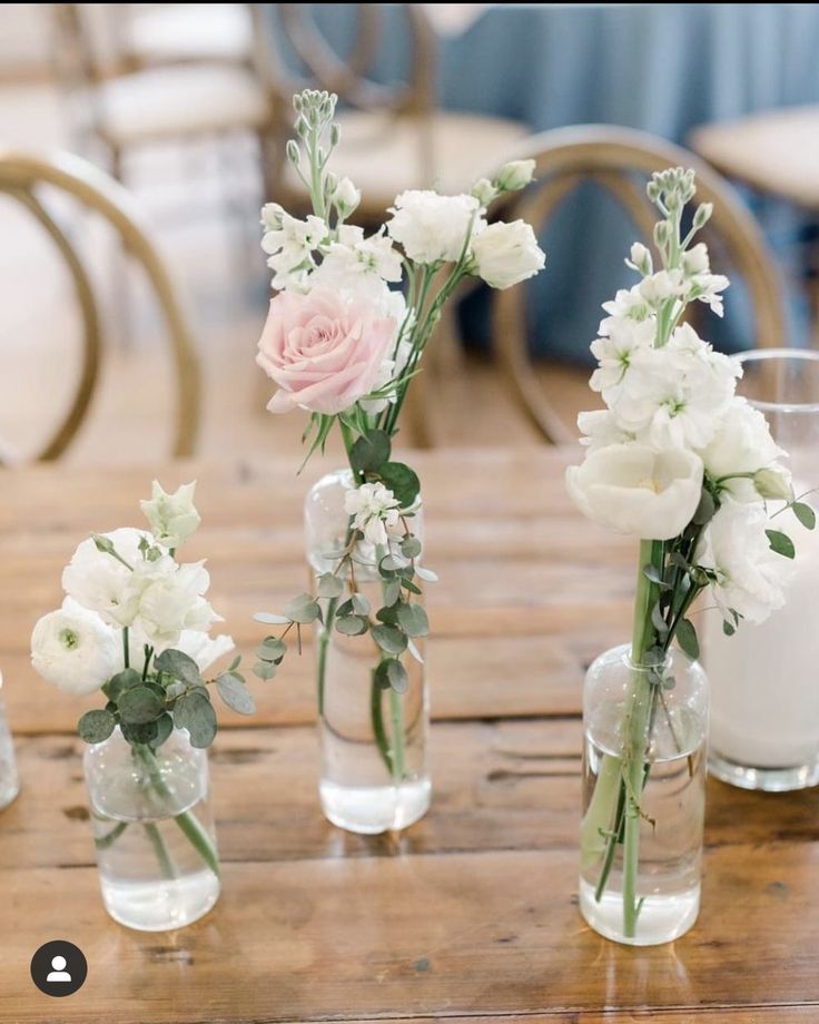 four vases with flowers are sitting on a table