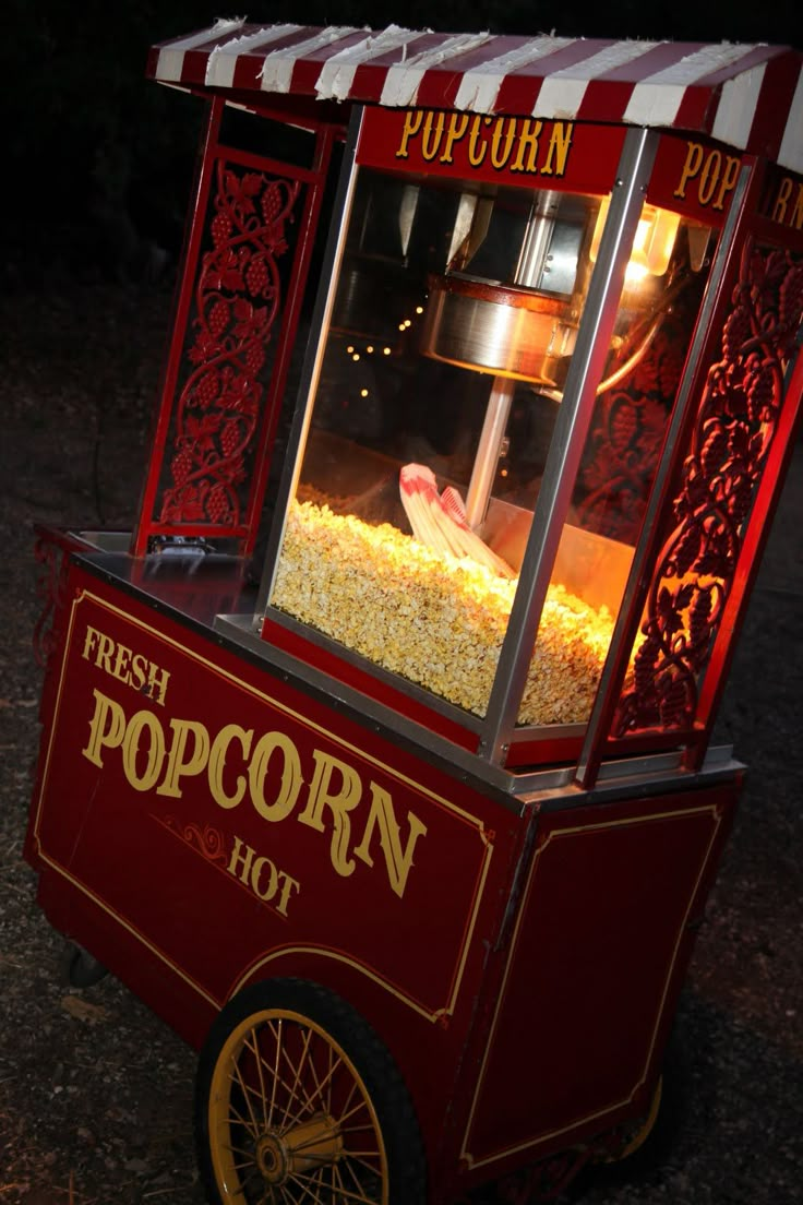 a popcorn cart sitting on top of a field