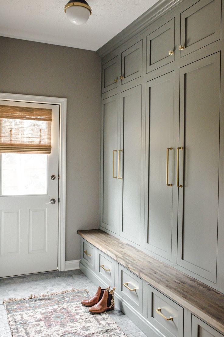 a room that has some cabinets and shoes on the floor in front of it with a door