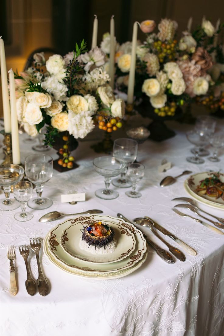 a white table topped with plates and silverware