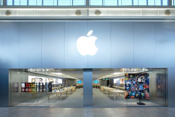 an apple store is shown with its reflection in the glass door and it's logo on the wall