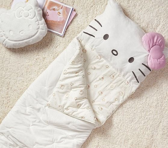 a hello kitty sleeping bag and other items on the floor