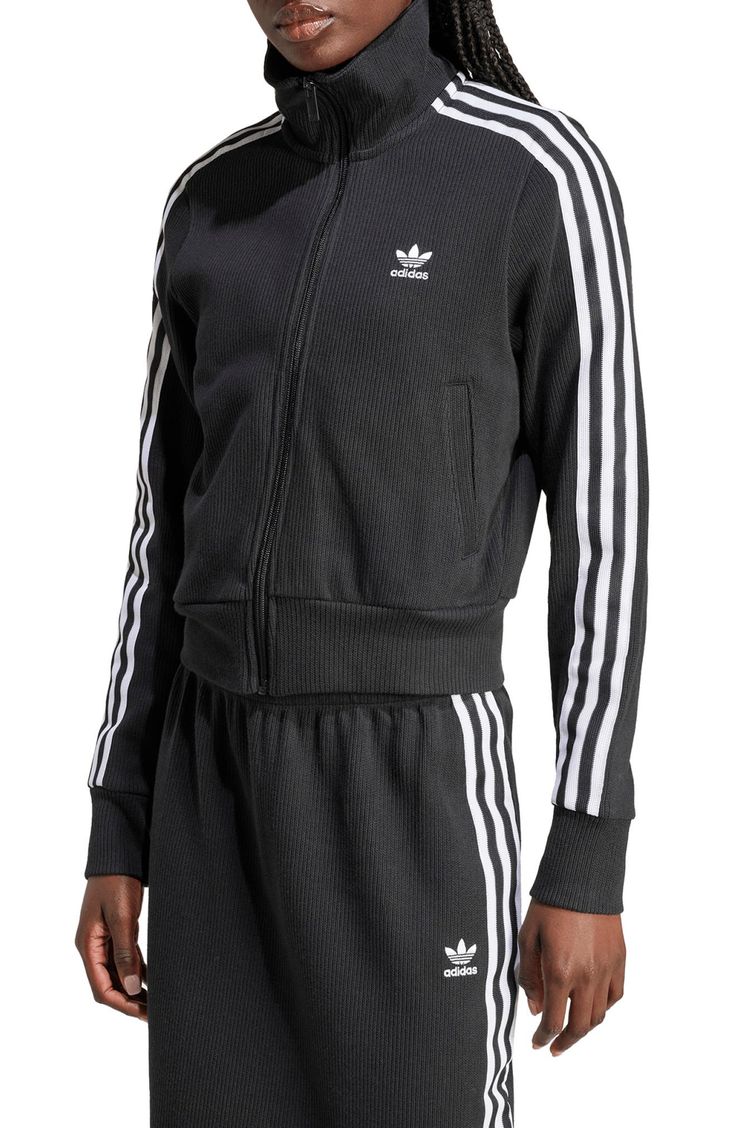 Made from a blend of cotton and recycled yarns, this ribbed track jacket with the 3-Stripes will keep you both comfy and sporty. Front zip closure Stand collar Front welt pockets 79% cotton, 21% recycled polyester Machine wash, dry flat Imported Fall Athleisure Activewear With Three Stripes, Spring Track Jacket With Three Stripes Branding, Sportswear Track Jacket With Ribbed Cuffs, Winter Athleisure Track Jacket With Ribbed Cuffs, Relaxed Fit Athleisure Track Jacket With Ribbed Cuffs, Fall Athleisure Cotton Track Jacket, Fall Sportswear Track Jacket With Three Stripes, Fall Track Jacket With Three Stripes Branding, Cotton Sportswear Track Jacket With Ribbed Cuffs