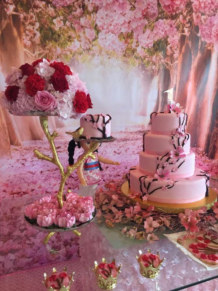 a table topped with three tiered cakes covered in pink and red flowers next to each other