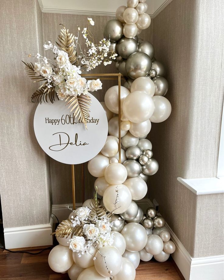 a balloon arch with white and silver balloons