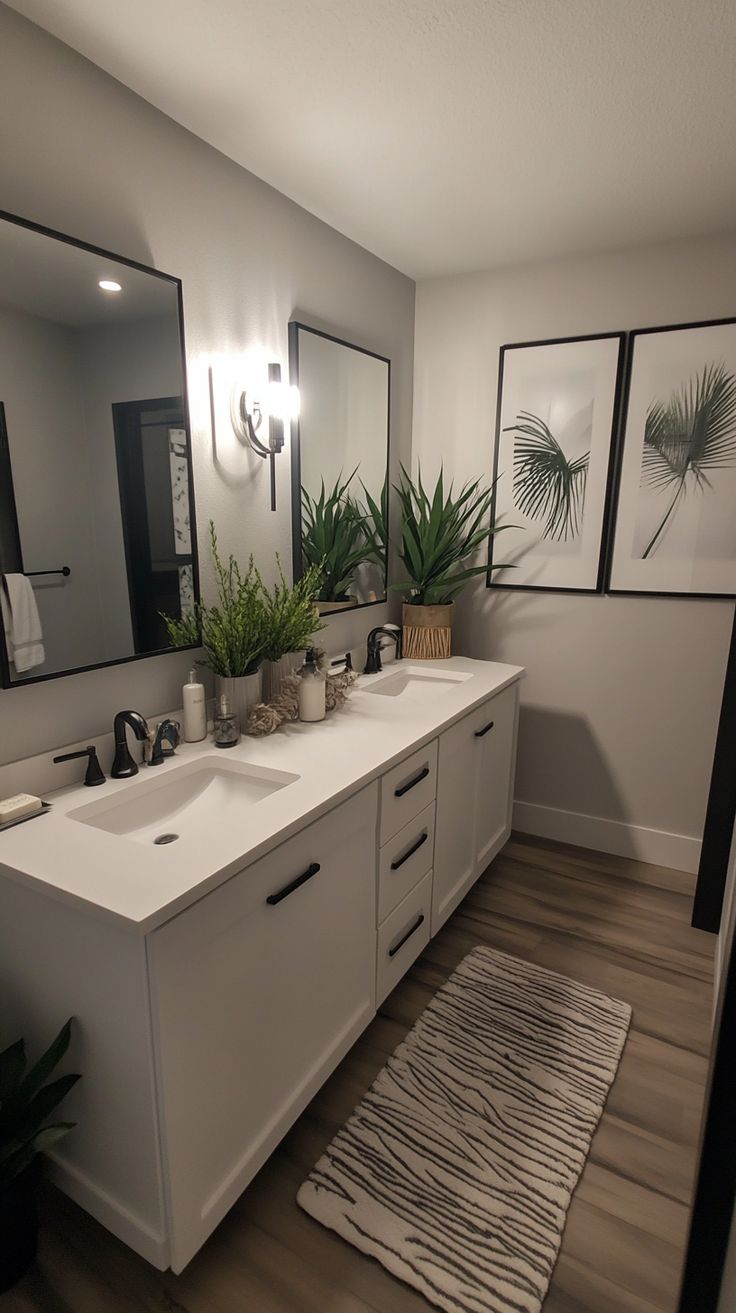 a bathroom with two sinks, mirrors and plants