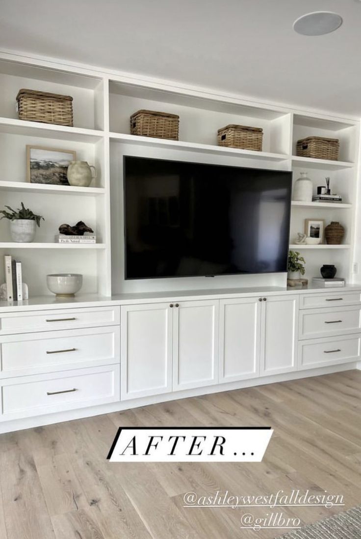 a white entertainment center with built - in shelving and wicker baskets