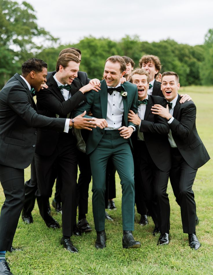 a group of men in tuxedos are posing for a photo with each other