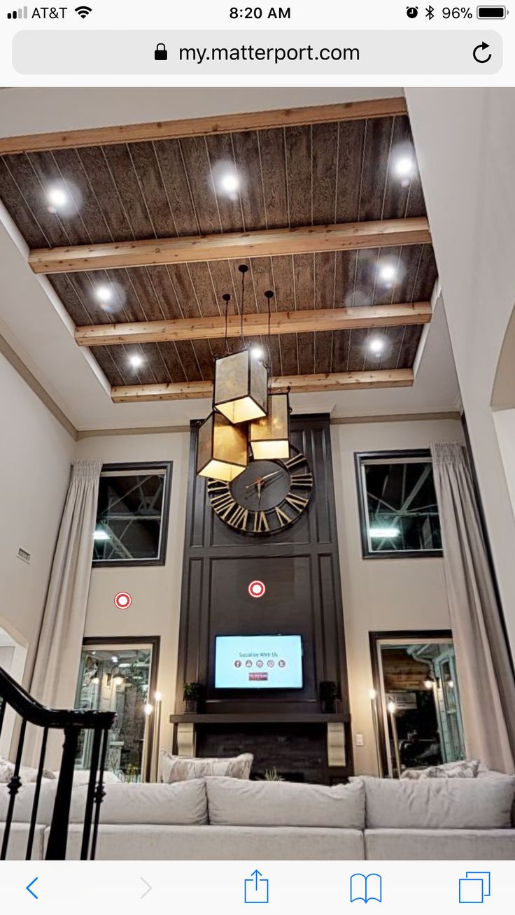 a living room filled with furniture and a large clock mounted to the ceiling above it