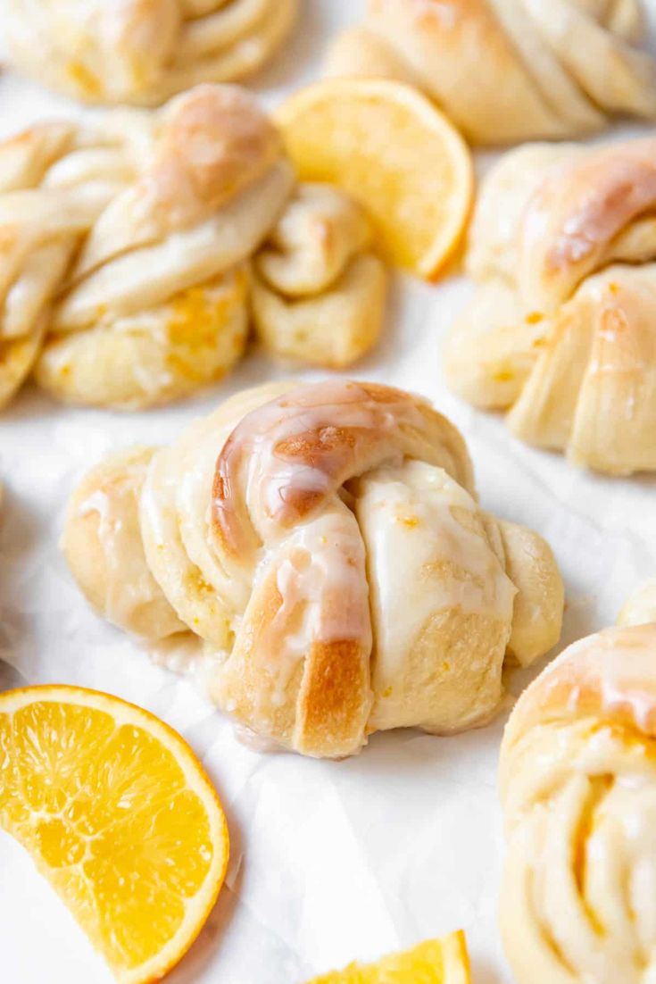 orange rolls with icing and sliced oranges on the side