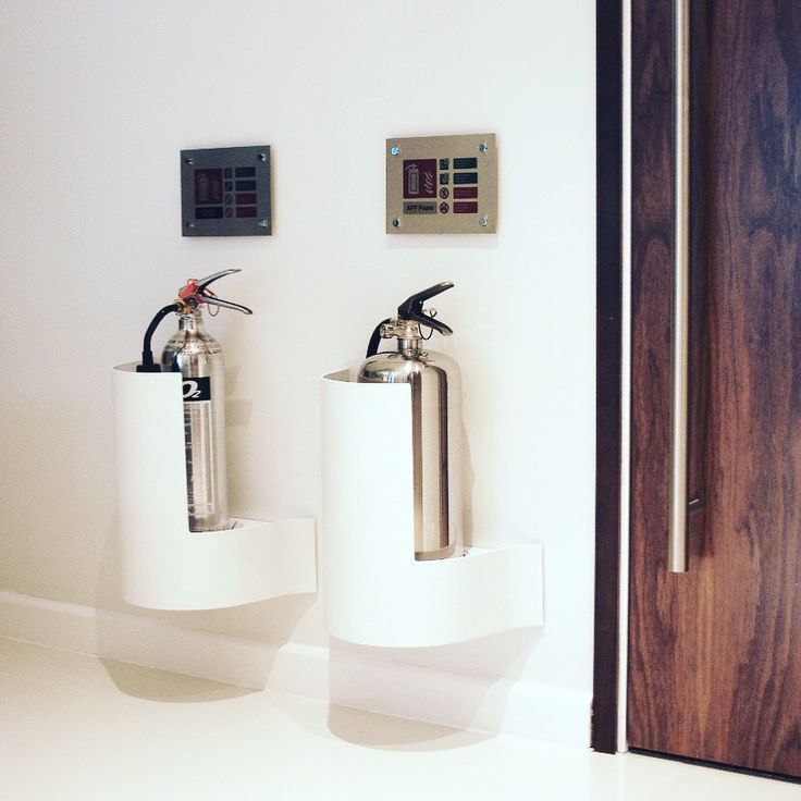 two water tanks sitting next to each other on the wall in front of a door