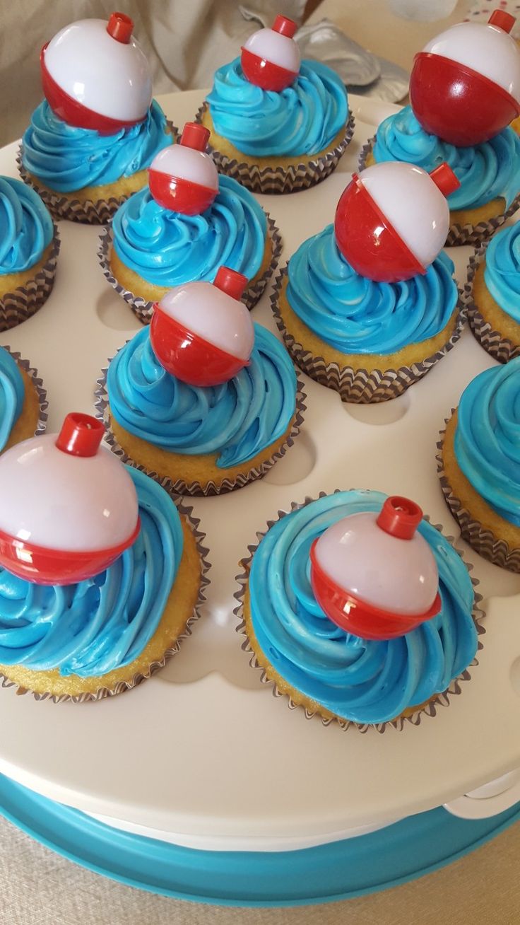 cupcakes with blue frosting and red decorations on a platter, ready to be eaten