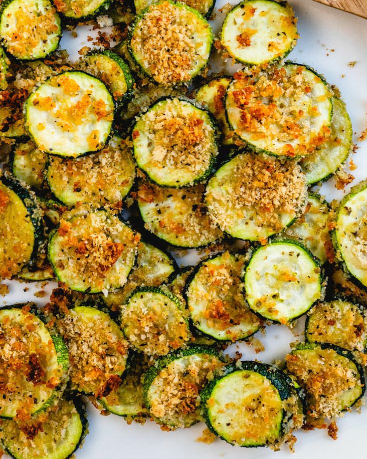 cooked zucchini with parmesan cheese and seasoning on a white plate