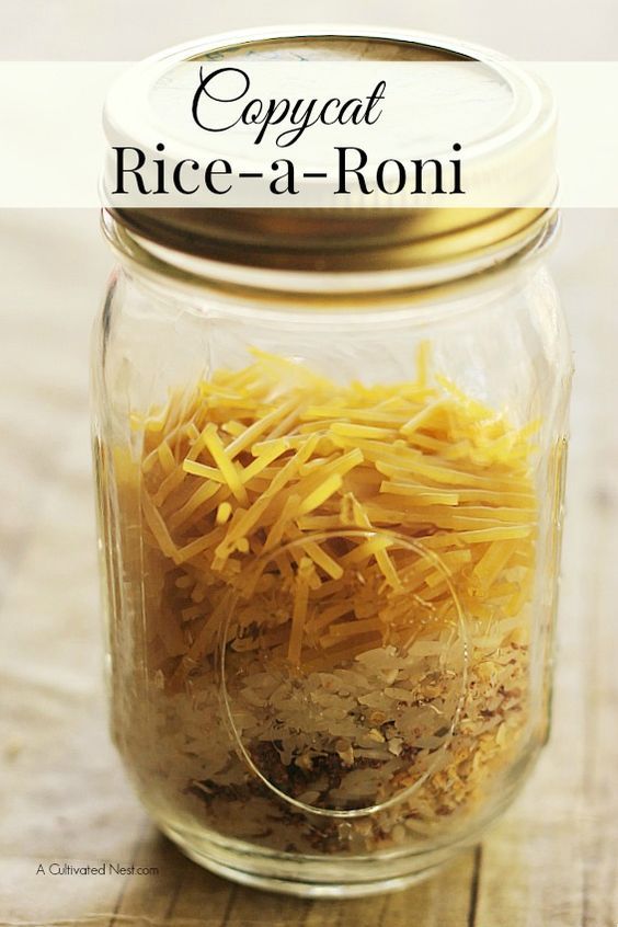 a jar filled with rice and cheese on top of a wooden table