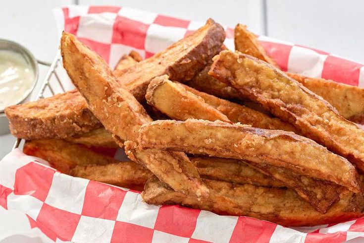 fried french fries in a basket with dipping sauce on the side, ready to be eaten