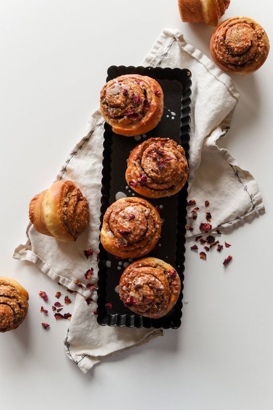 several pastries sitting on top of a black tray next to some cranberries