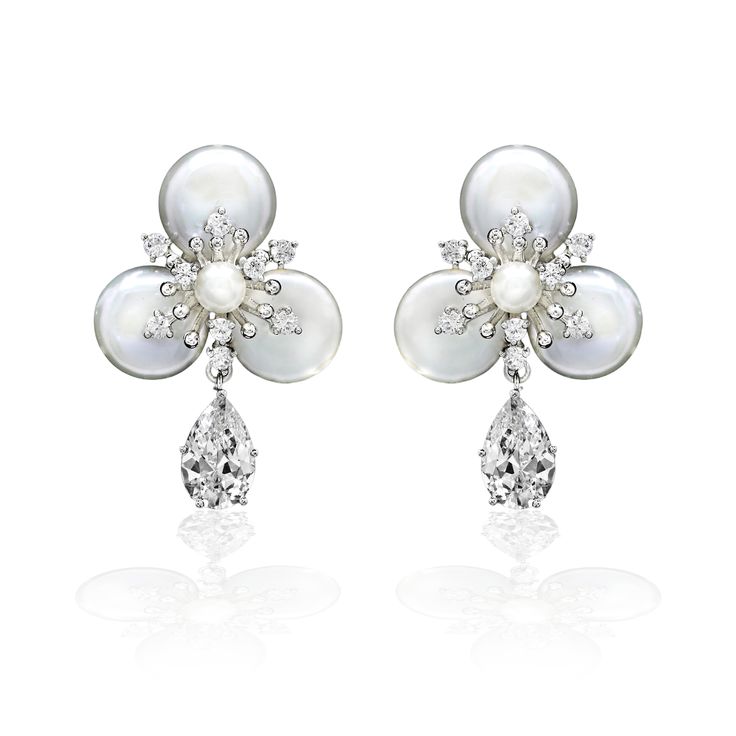 Exquisitely crafted, these earrings perfectly capture the romance of your special day. The design boasts a single pear-like cubic zirconia gemstone suspended elegantly from a luscious pearl flower. Crafted with utmost care, these earrings measure 1.5 inches long and are made from a durable alloy, free of lead, nickel, and cadmium. Matching bracelet here. Pear-shaped Pearl Drop Bridal Earrings In White Gold, Elegant Flower Earrings With Sparkling Stones For Wedding, Elegant Wedding Flower Earrings With Sparkling Stones, Elegant Dangle Clip-on Flower Earrings, Elegant Clip-on Dangle Flower Earrings, Elegant Flower Earrings With Sparkling Stones For Anniversary, Pearl White Diamond Earrings For Wedding, Diamond Bridal Earrings With Pearl Drop For Anniversary, Formal Dangle Flower Earrings With Pearl Drop