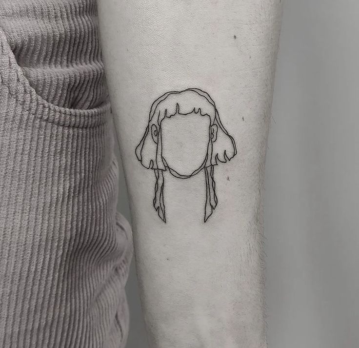 a woman's head with a ponytail tattoo on the left inner forearm and arm