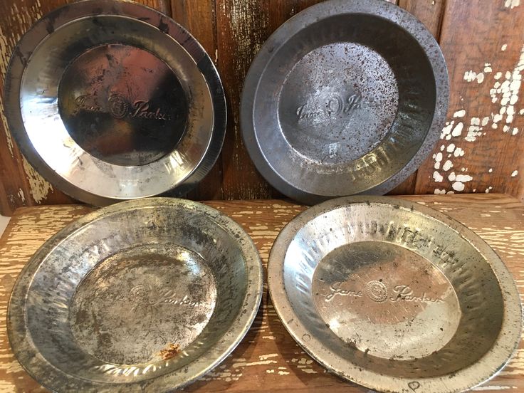 three metal bowls sitting on top of a wooden table