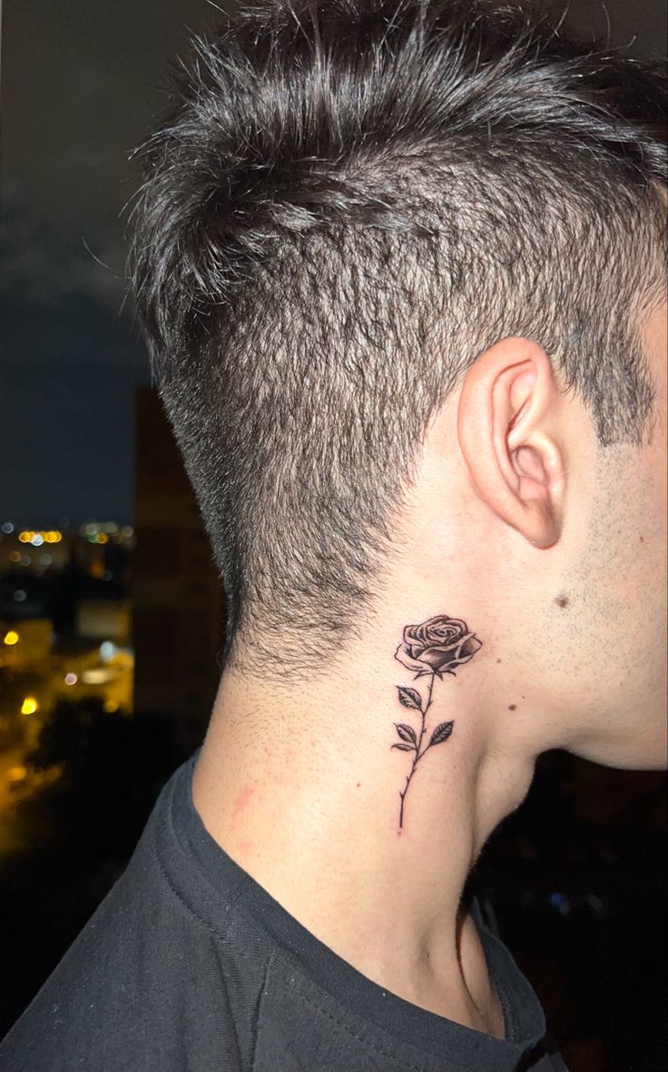 a man's neck with a rose tattoo on the top of his left ear