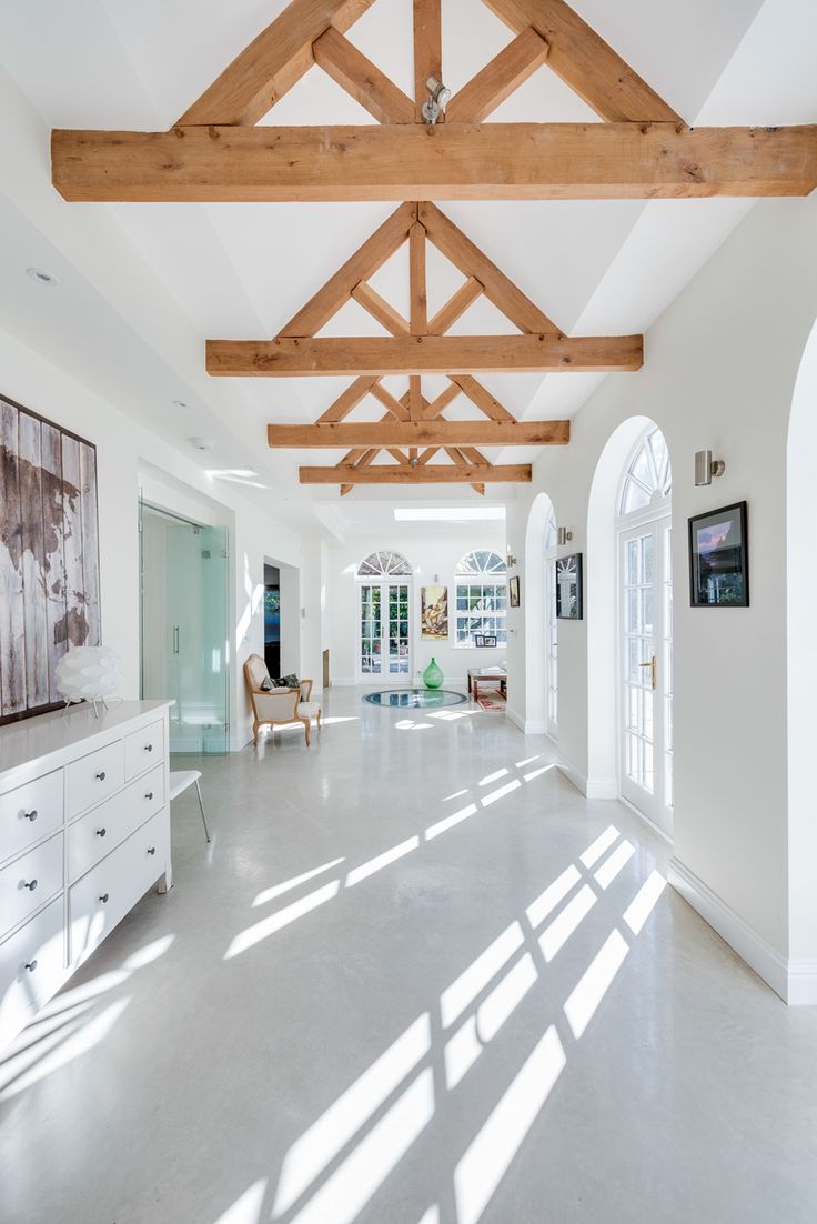 a large open room with white walls and wooden beams