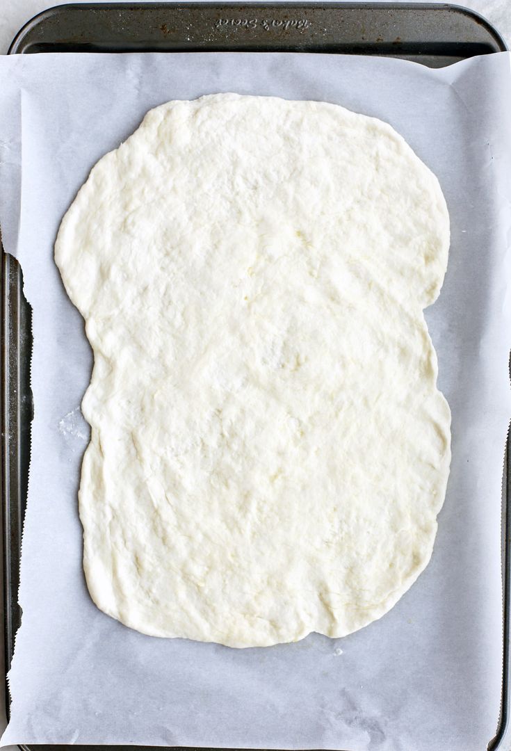 an uncooked tortilla on a baking sheet ready to go into the oven