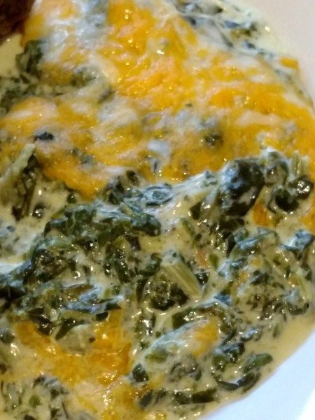 a white bowl filled with spinach and cheese