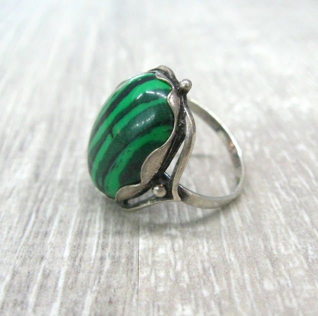 Vintage fashion jewelry, Malachite imitation woman's ring in size 9. Only 1 item available, not adjustable and not resizeable. Very good condition. Size: 9 ( US and Canada ), R 3/4 ( UK and Australia ), 19 ( Europe ). Stone: stripy green MAlachite imitation ( AKA pressed stone or reconstituted malachite ) The stone is oval shape, measuring 14X10 mm and standing 7 mm tall over the finger surface. Material: Silver plated brass. This is a high quality ring in electric silver plate with 980 silver t Adjustable Fit Emerald Ring, Green Turquoise Cabochon Ring, Vintage Green Turquoise Ring, Green Emerald Cabochon Rings, Green Open Ring Jewelry For May Birthstone, Green Cabochon Ring Jewelry, Adjustable Turquoise Gemstone Ring, Adjustable Green Turquoise Gemstone Ring, Vintage Green Turquoise Cabochon Ring