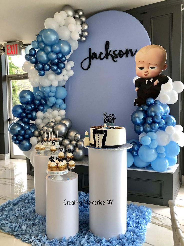 a baby shower with balloons, cake and cupcakes