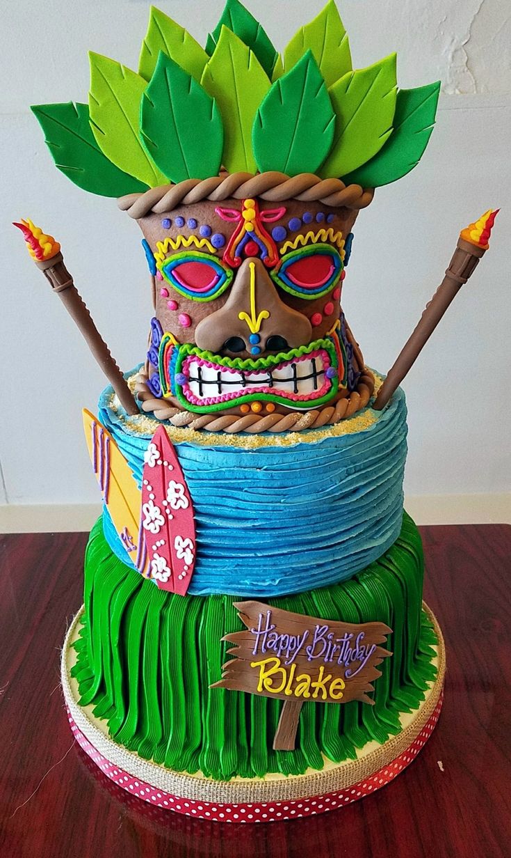 a birthday cake made to look like a hula skirt and headdress with leaves on top