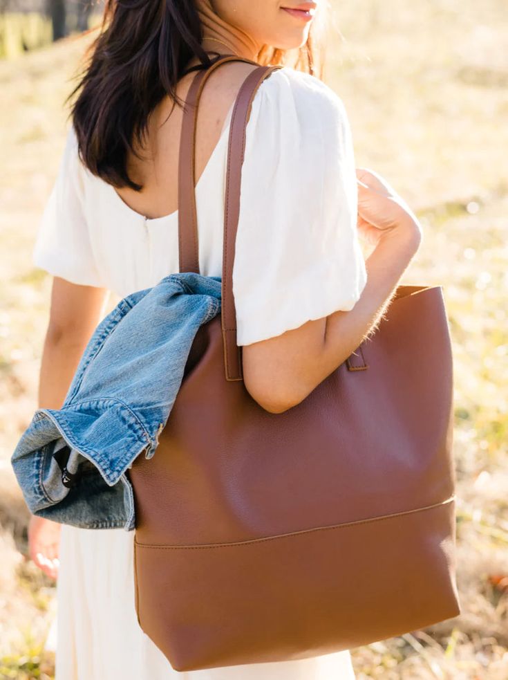 Our lifetime favorite and consistent bestseller, the Mamuye Classic Tote is the perfect everyday tote. Crafted with the highest quality, this bag is made to stand the test of time. Handcrafted in Ethiopia Unlined interior 100% leather Tote measures 14" H x 16" W x 6" D Comfortable, durable straps (straps have a 10.5" drop) Interior pocket Subtle variations add to the uniqueness of each product Product naturally produces a distressed look with wear This product is named after one of the heroic wo Classic Everyday Bucket Bag With Smooth Grain, Versatile Tote Shoulder Bag With Smooth Grain, Versatile Smooth Grain Tote Shoulder Bag, Brown Bags For Fall, Brown Smooth Grain Bags For Fall, Classic Hobo Bag With Smooth Grain, Classic Smooth Grain Hobo Tote Bag, Classic Hobo Bag Tote With Smooth Grain, Versatile Cognac Bag With Smooth Grain