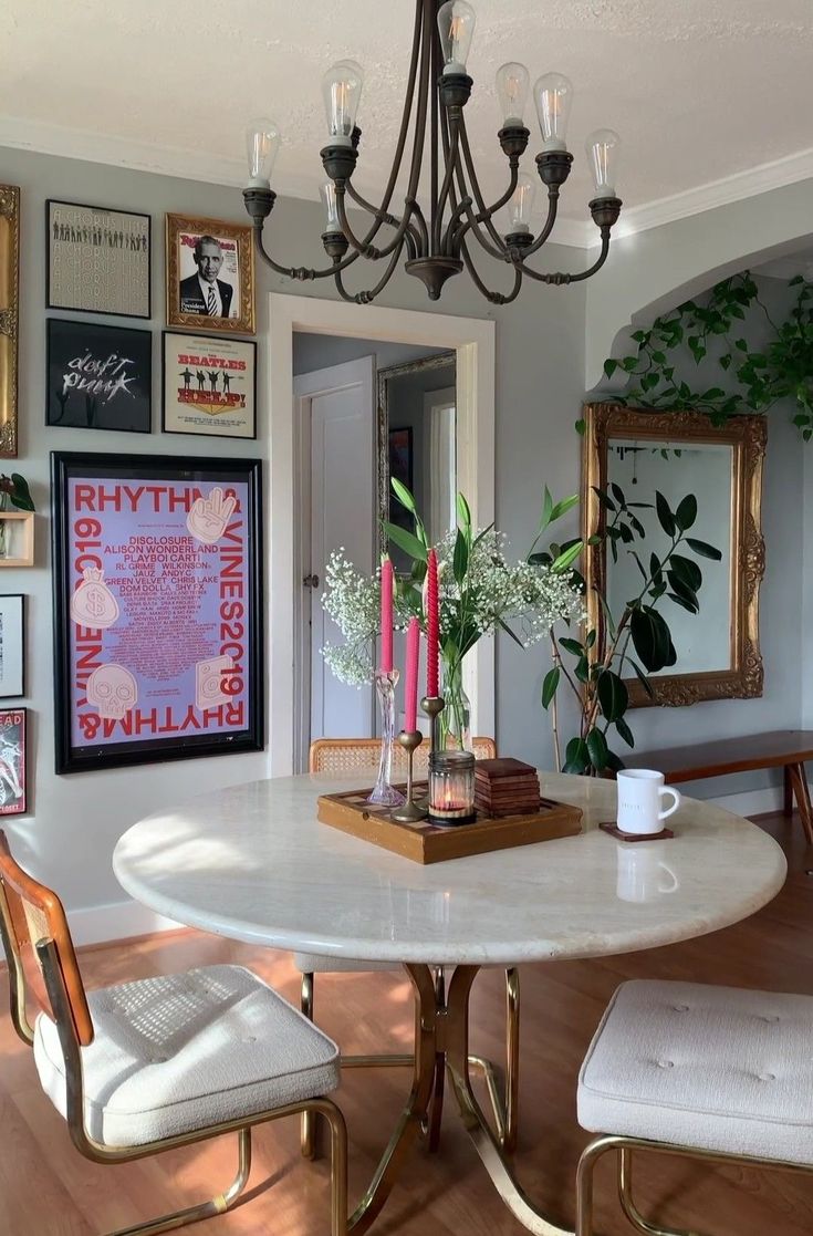 a dining room table with chairs and pictures on the wall