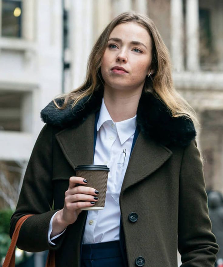 a woman holding a coffee cup while walking down the street