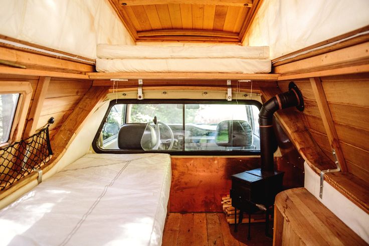 the inside of a camper with a bed and window