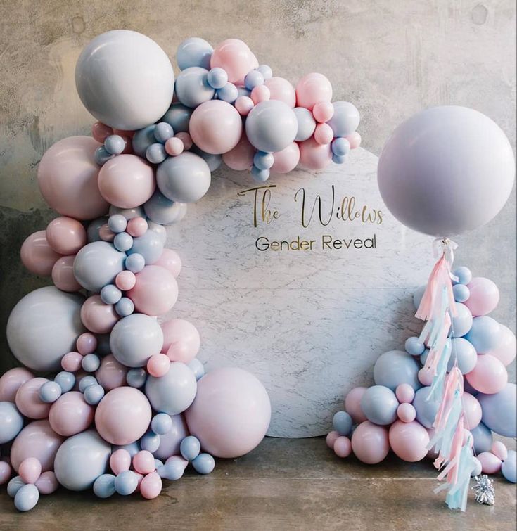 the balloon arch is decorated with pastel colors