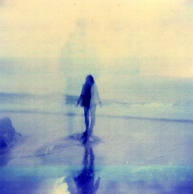 a blurry image of a person walking on the beach