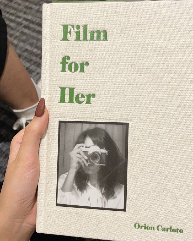 a person holding up a book about film for her