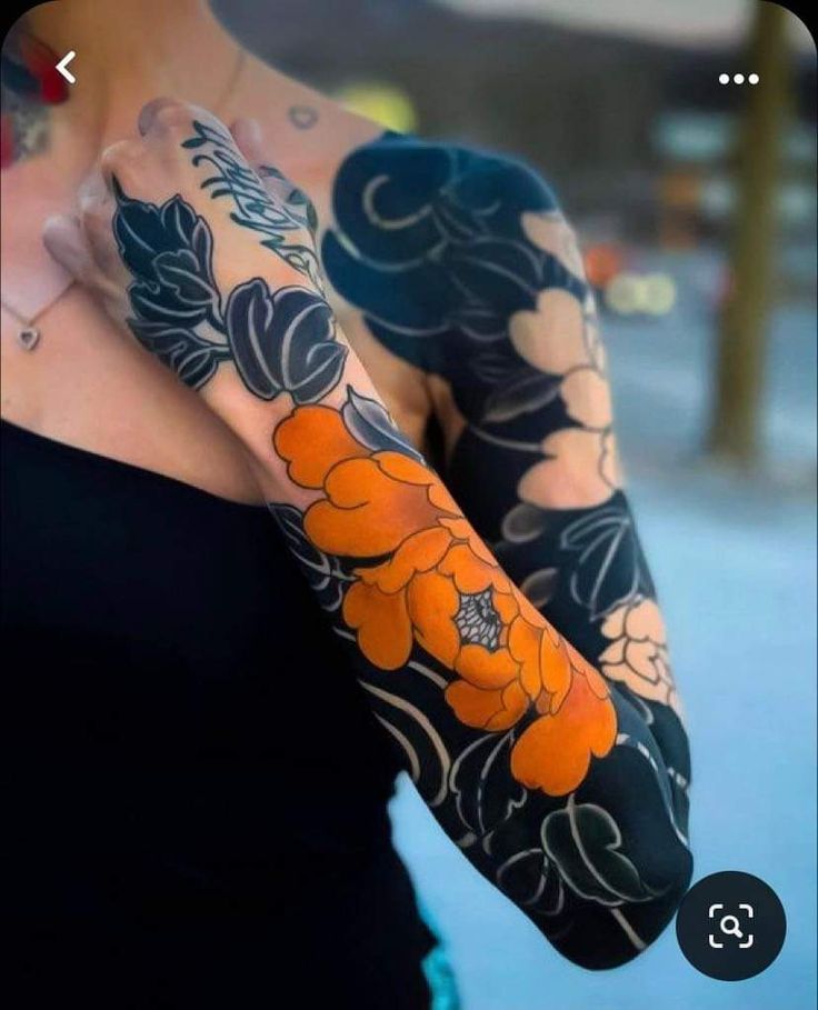 a woman with tattoos on her arms and arm sleeve covered in orange flower tattoo designs