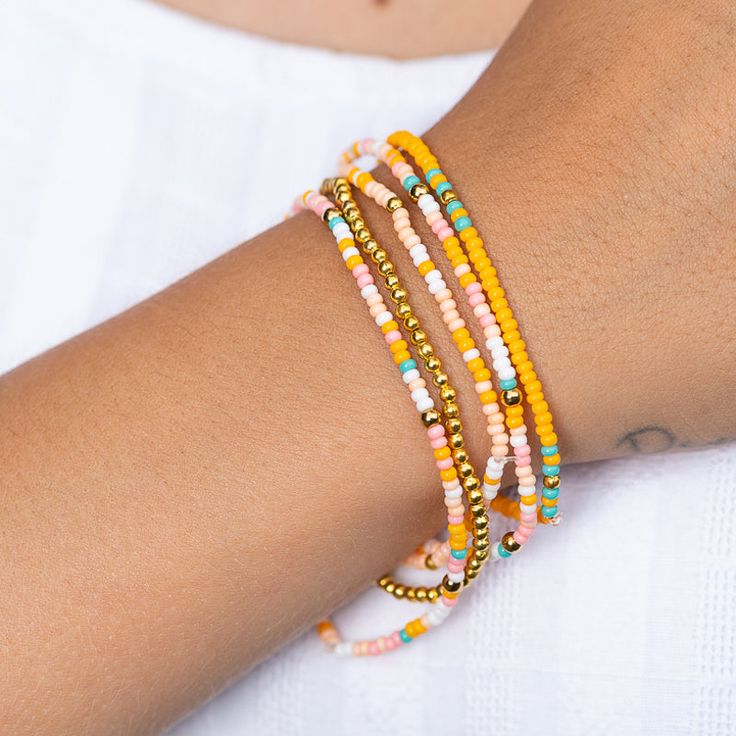 Get ready to rock the ultimate summer look with the Tropical Bracelet! This playful bracelet is a burst of beachside fun, featuring a vibrant mix of orange, white, teal, and pink beads, all accented with gleaming gold-colored details. Perfect for adding a splash of tropical flair to any outfit, the Tropical Bracelet is your go-to accessory for an endless summer vibe. Get ready to shine and bring the island magic wherever you go! Matching necklace and earrings sold separately. Coral Beaded Bracelets For Beach, Coral Beaded Beach Bracelets, Coral Round Beads Bracelets For Beach, Coral Round Beaded Bracelets For Beach, Coral Beaded Bracelets For The Beach, Coral Round Beads Bracelet For Beach, Colorful Beaded Yellow Bracelets For Vacation, Orange Tiny Beads Bracelets For Summer, Gold Friendship Bracelets With Colorful Beads For The Beach