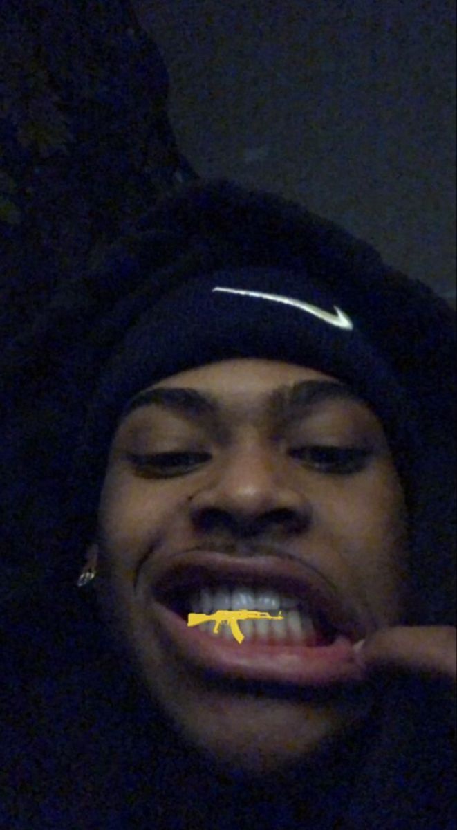 a young man is brushing his teeth with yellow toothpaste on his mouth while wearing a black hoodie