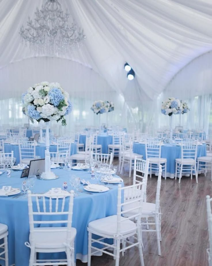 the tables are set up with blue and white linens for an elegant wedding reception