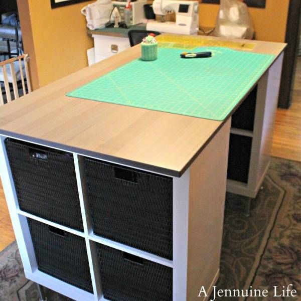 a kitchen island with baskets on it in front of a counter top and sewing machine