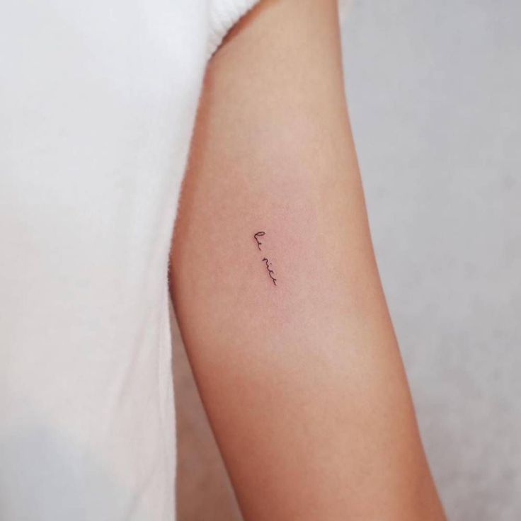 a woman's arm with a tiny tattoo on the left side of her arm